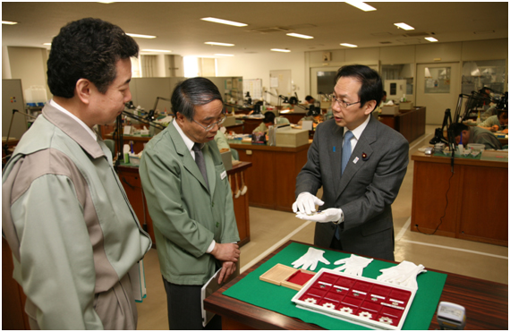 勲章の製造を行っている装金課工場を視察する竹内政務官=8日 勲章の製造を行っている装金課工場を視察する竹内政務官=8日